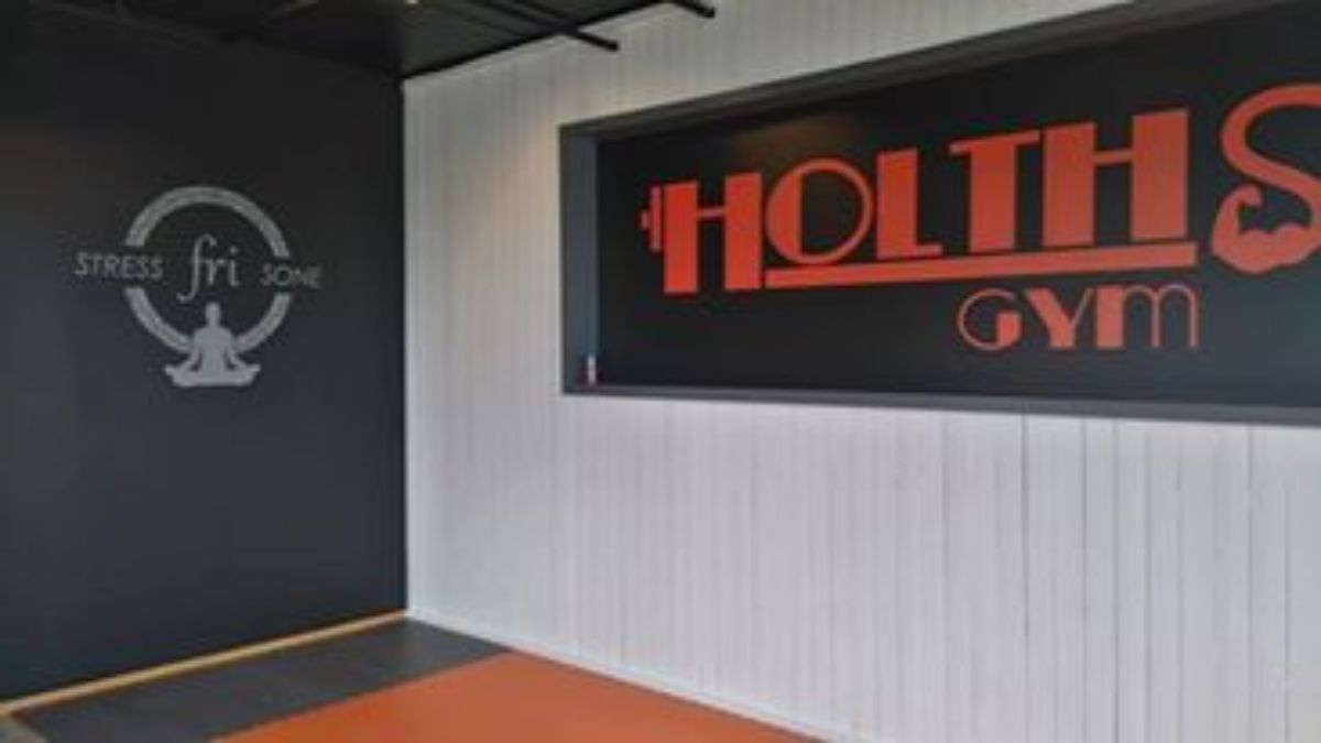 Tekst "Stress-fri sone" på vegg med stor logo Holths Gym