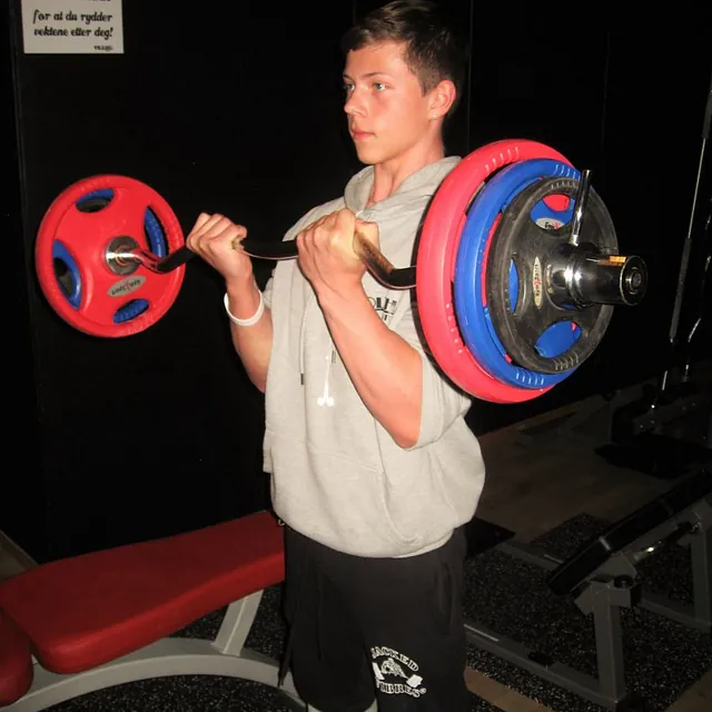 Mann i grå hettegenser trener bicepcurl