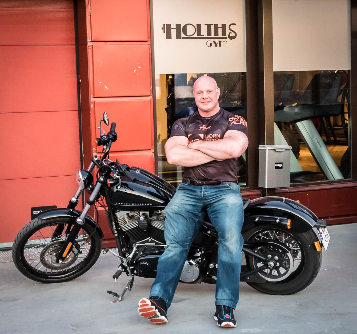 Gunnar Holth sitter på motorsykkelen sin utenfor treningsstudio