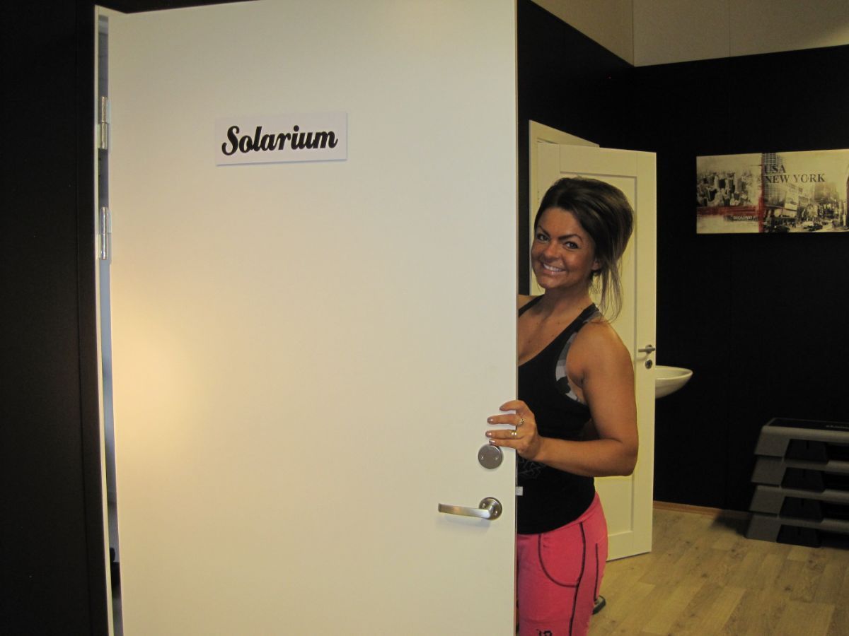 Kvinne åpner døren til solarium